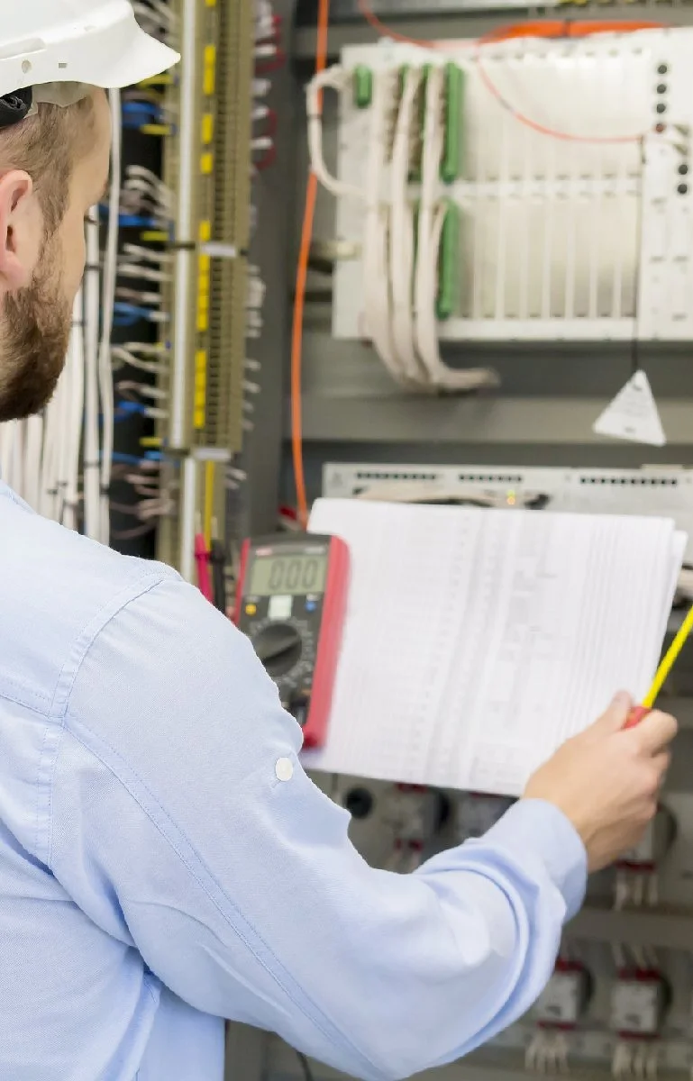 Elektryk sprawdzający rozdzielnicę elektryczną